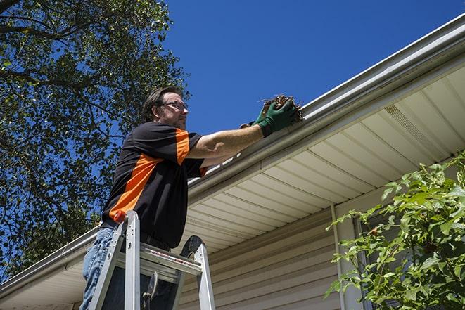 maintenance worker replacing a damaged gutter in Ashton MD